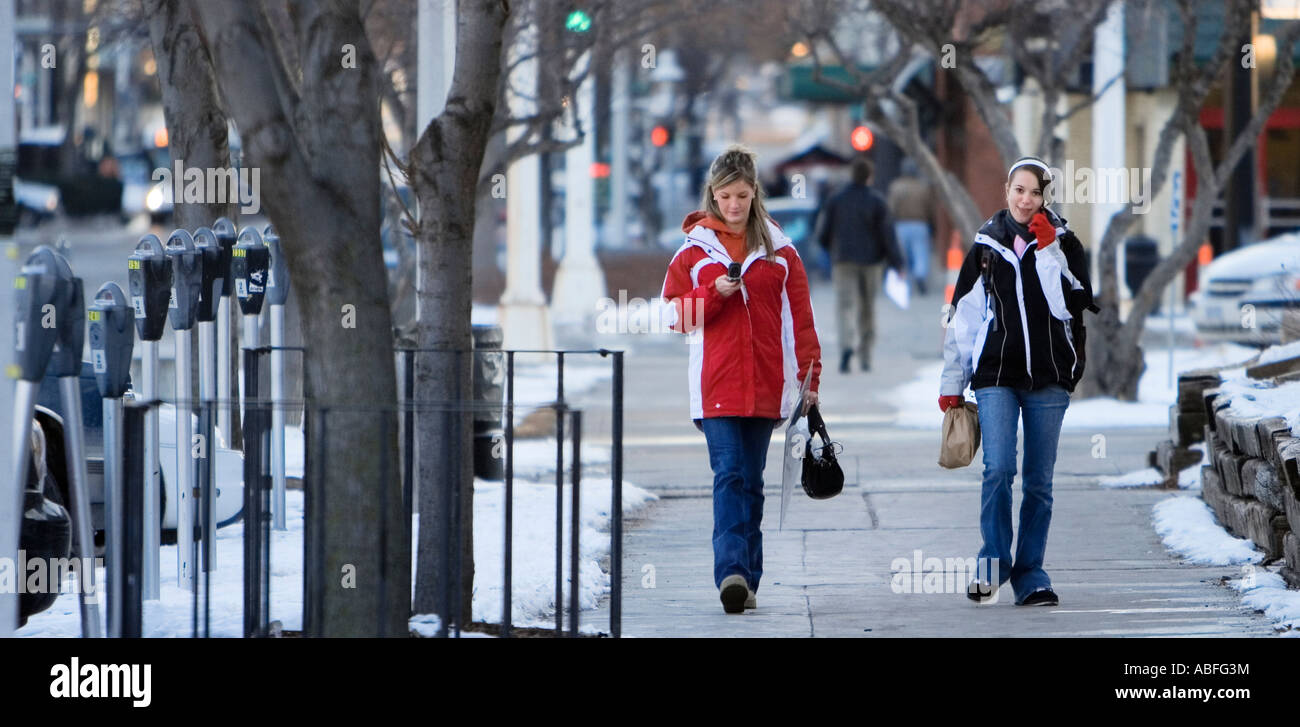 Two young women using cellphones in Lincoln, Nebraska. Stock Photo