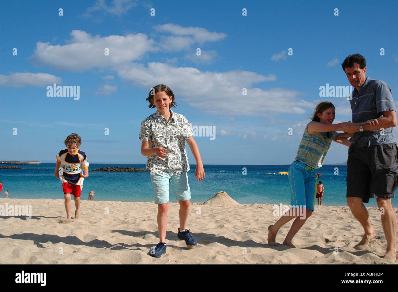 father and children on the beach on holiday Stock Photo