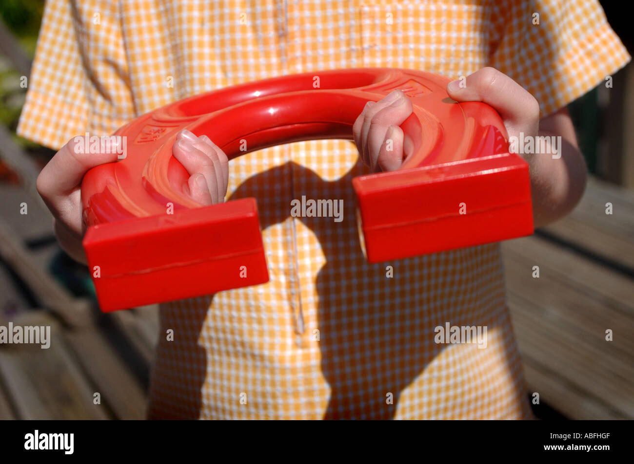 A young child holding a large plastic red magnet Stock Photo - Alamy