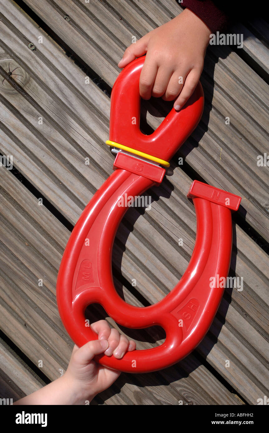 Children playing with large red plastic magnets at a nursery Stock Photo