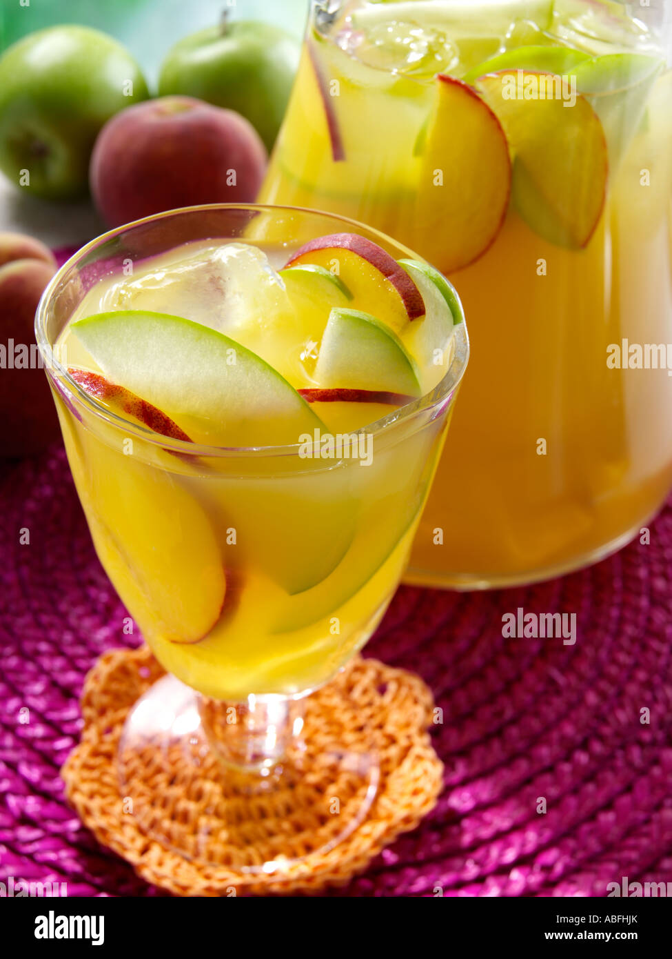 A glass and jug of Spanish white wine Sangria on a Garden table