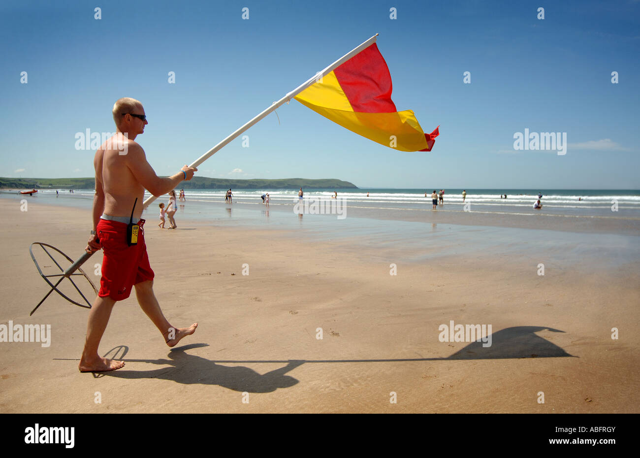 A lifeguard moving the red and yellow flag at on the beach at