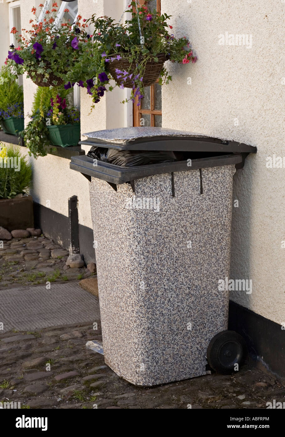 Waste wheelie bin covered in plastic to disguise its colour in