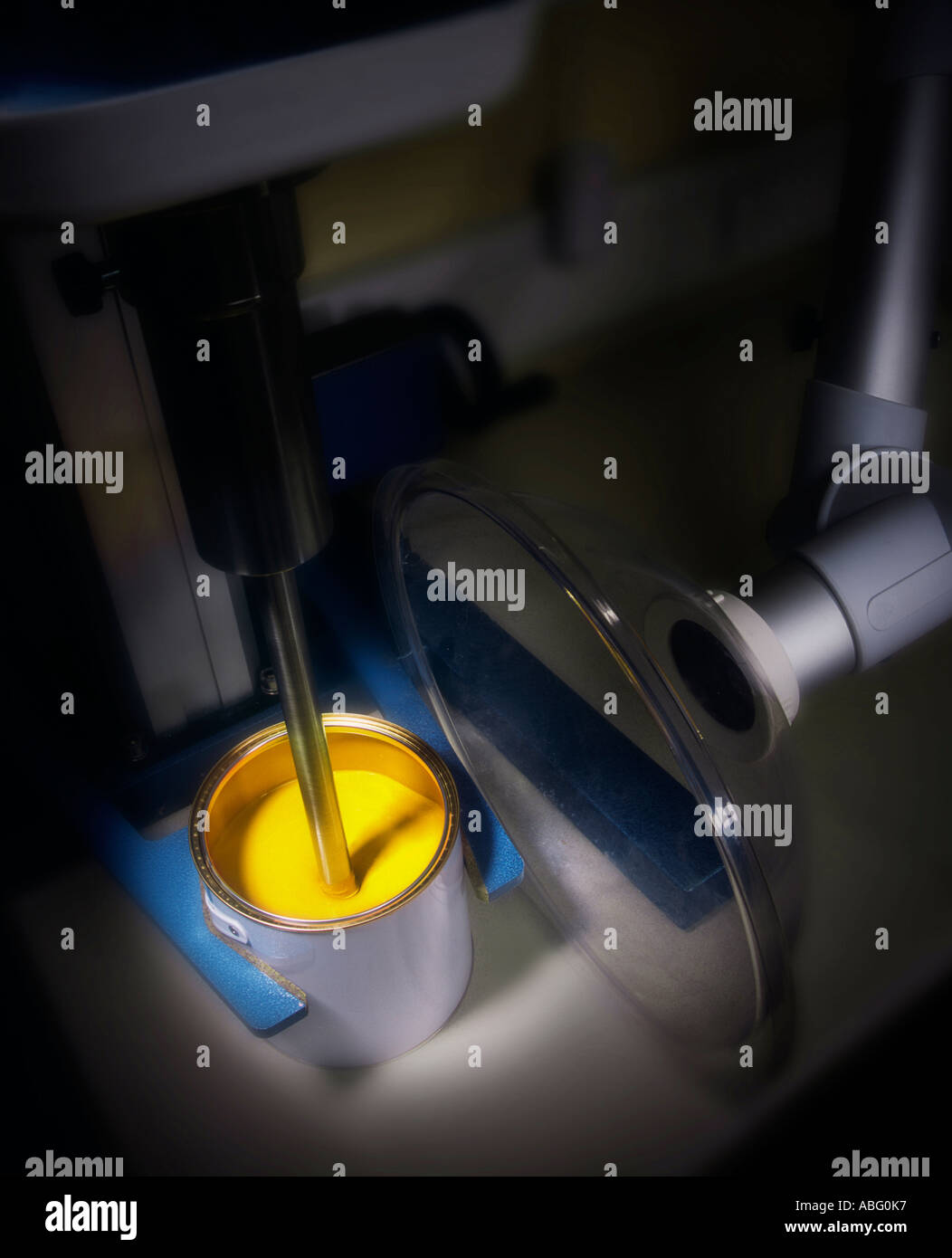 YELLOW PAINT IN TIN ON MIXING MACHINE Stock Photo