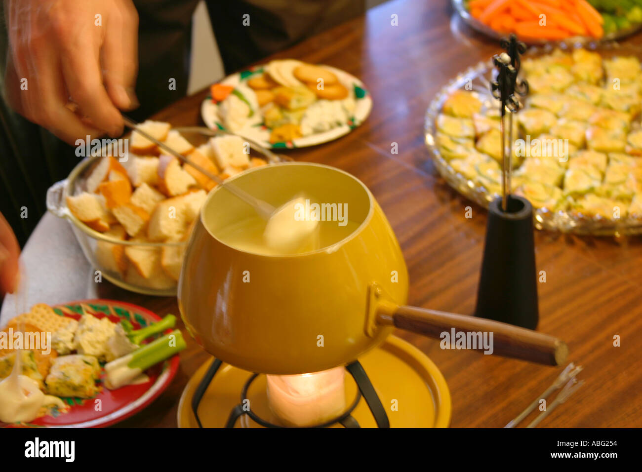 Dipping bread into Fondue pot Stock Photo Alamy