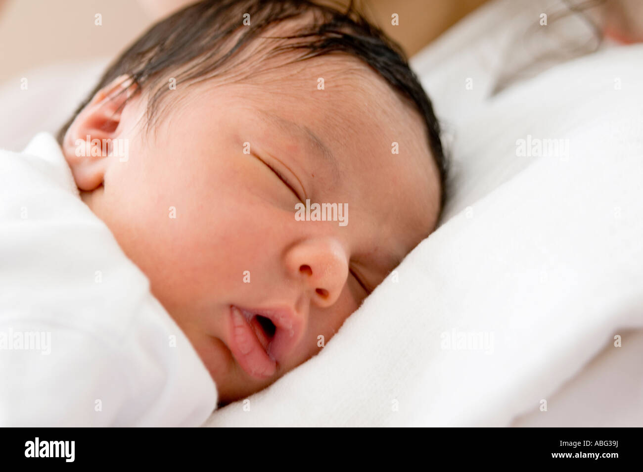 6 month old baby girl is sleeping over her mother's shoulders. Stock Photo