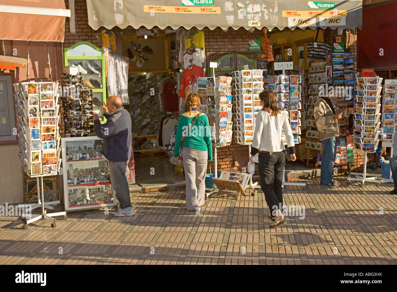 Visitors look at racks of post cards near Djemaa el-Fna Marrakech Morocco Stock Photo