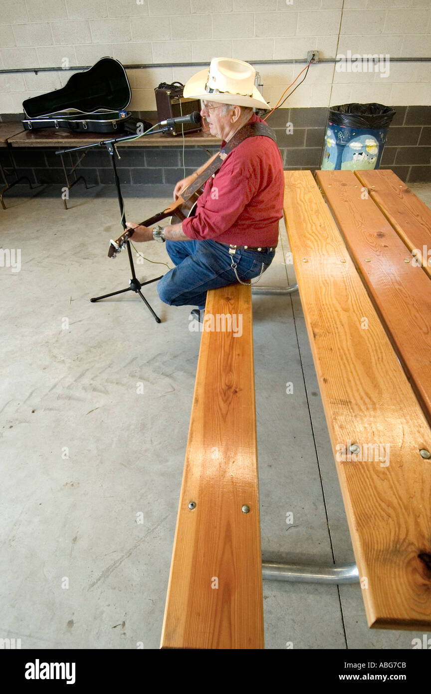 Senior males pays music on a guitar and sings country western song Stock Photo