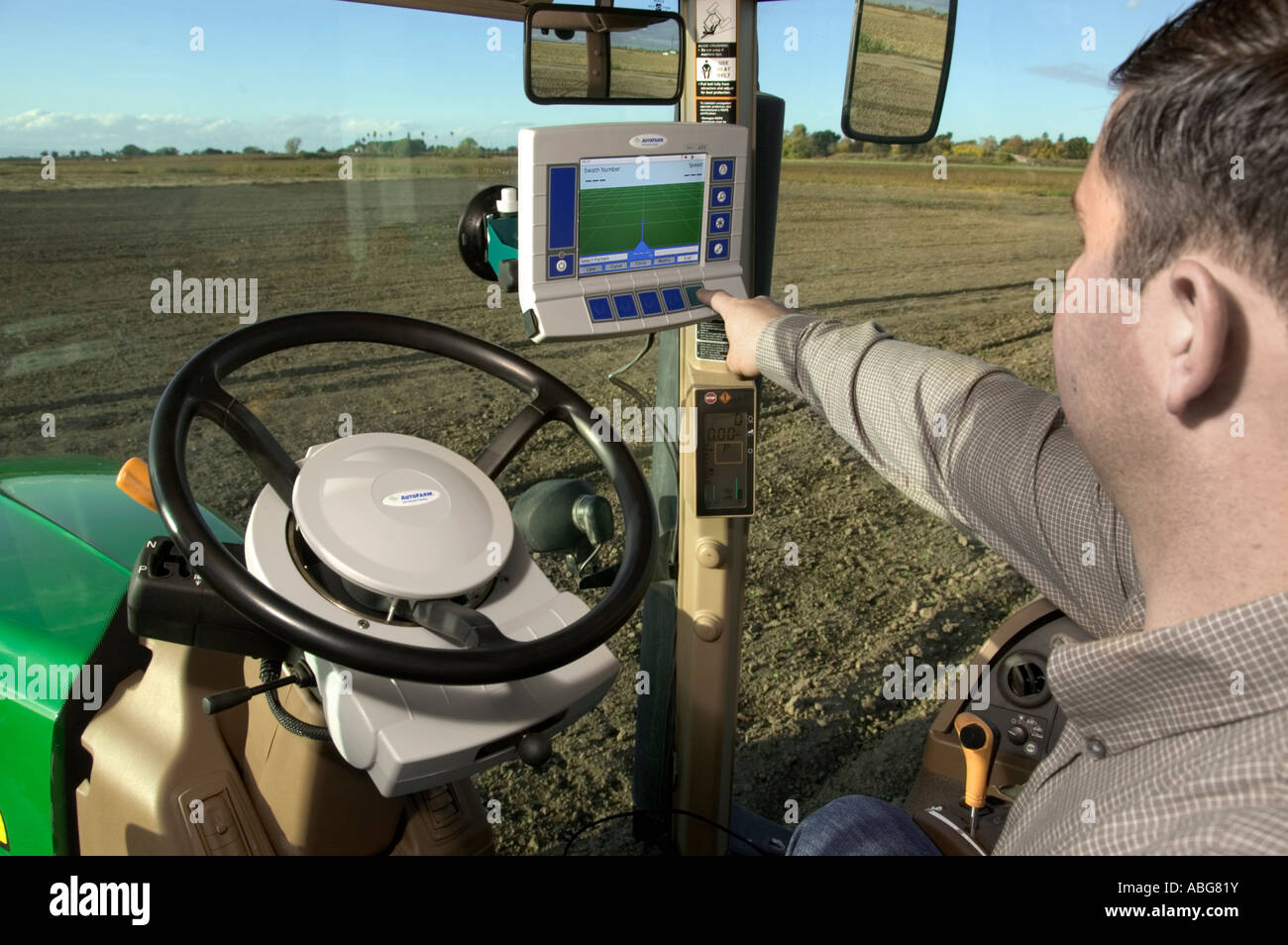 A tractor driver with GPS navigation for accurate field grading Stock