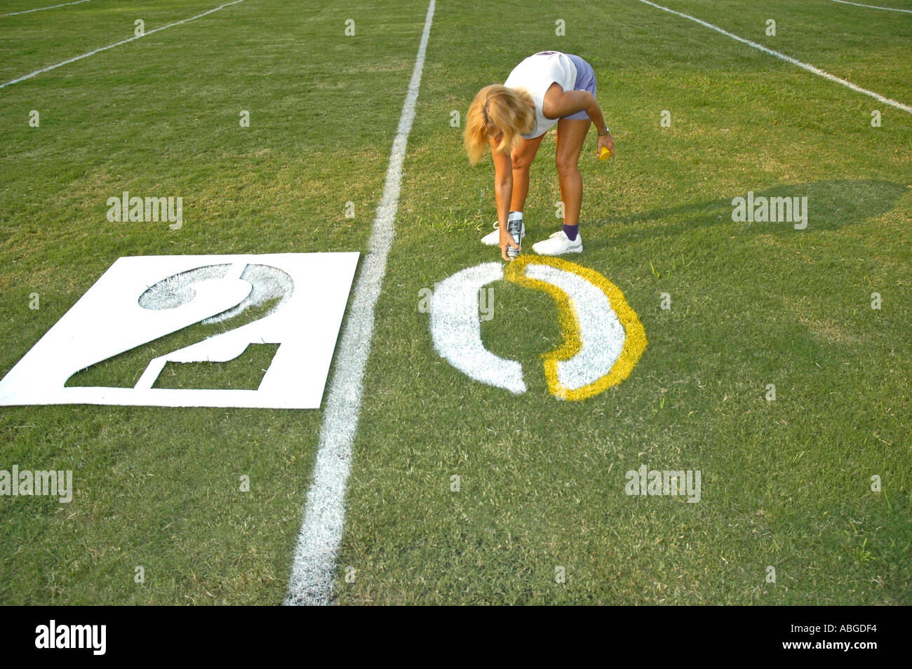Volunteers Painting yardage numbers and logos on football fields in
