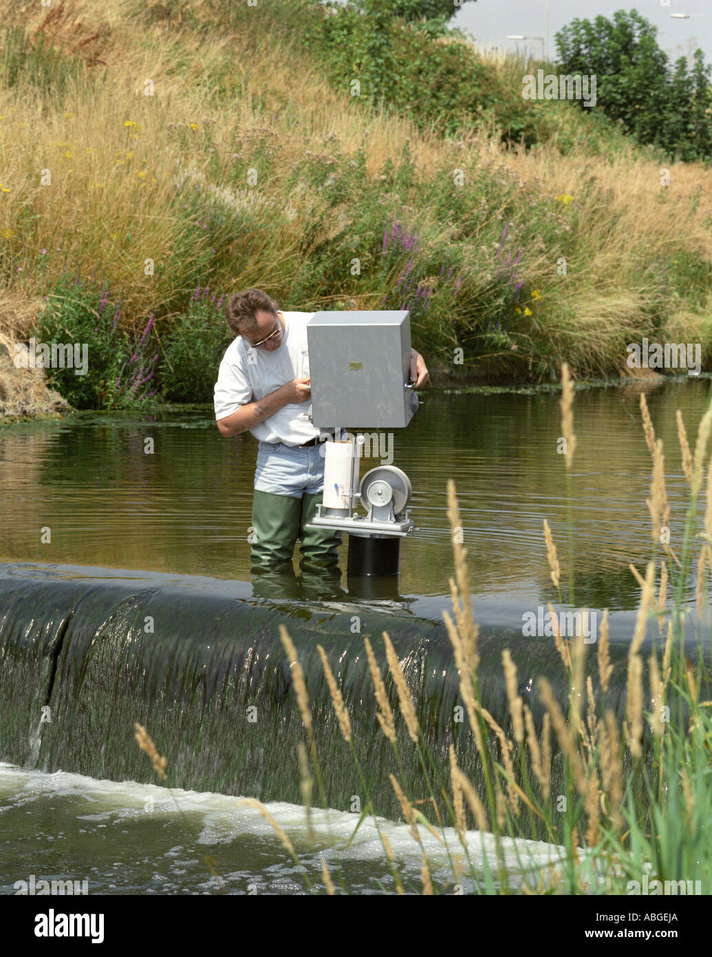 Water level recorder in a river, being adjusted by a scientist. Stock Photo