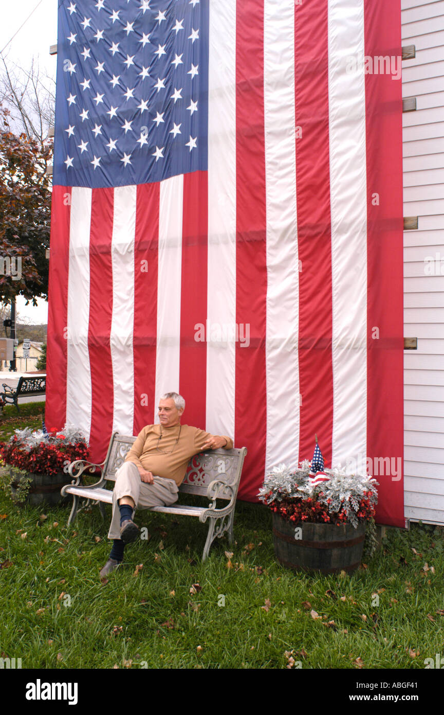 Home in Midwest Ohio with USA flag on it to show support of the war in Iraq with depressed man Stock Photo