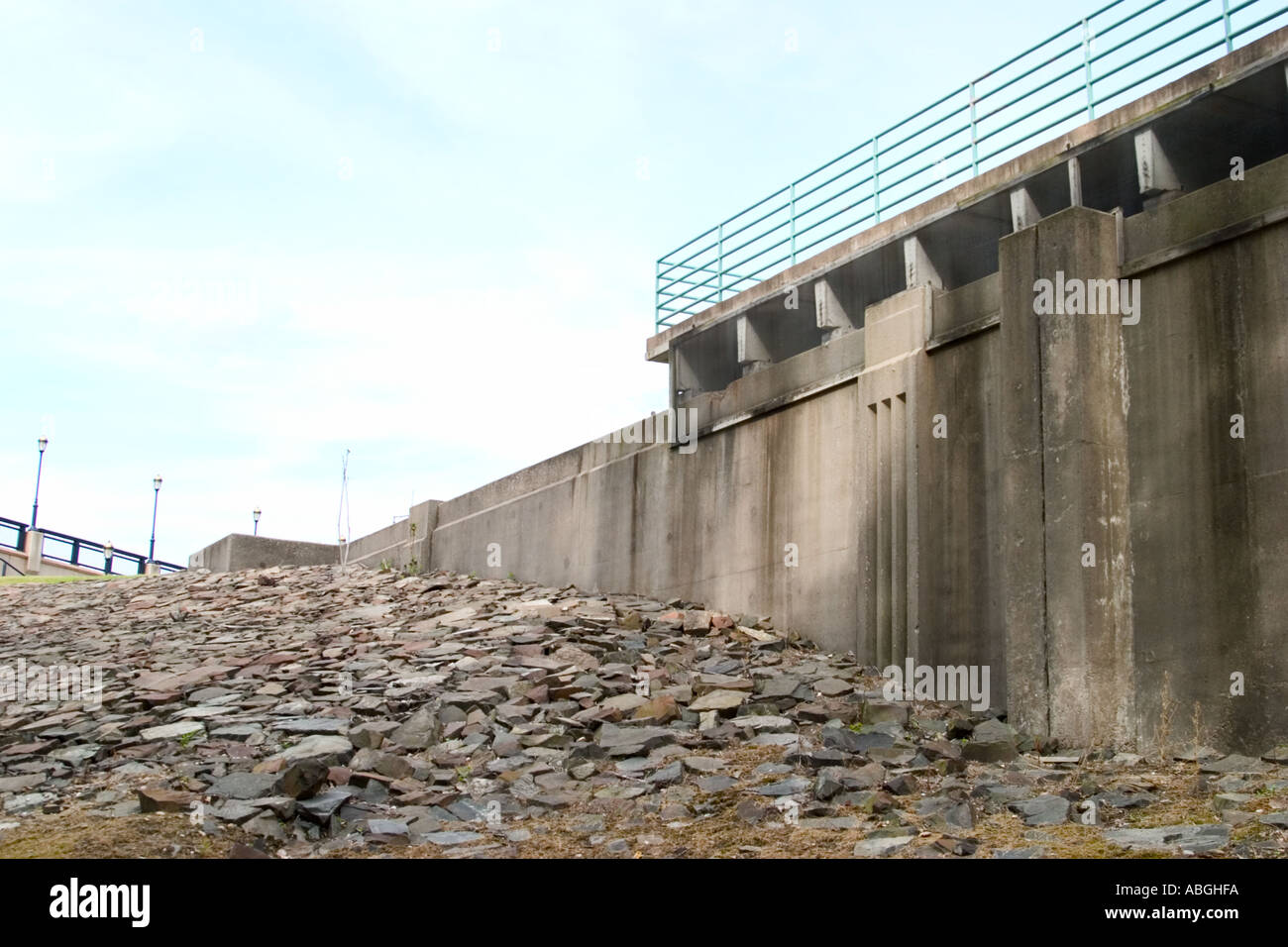 Concrete wall next to a large collection of rocks Stock Photo - Alamy