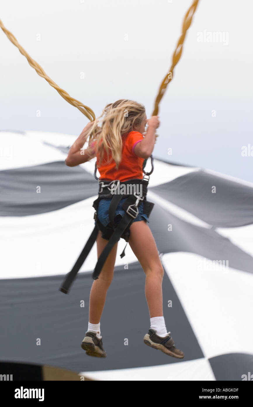 Young girl on a bungee cord type ride at a Connecticut USA fair Stock
