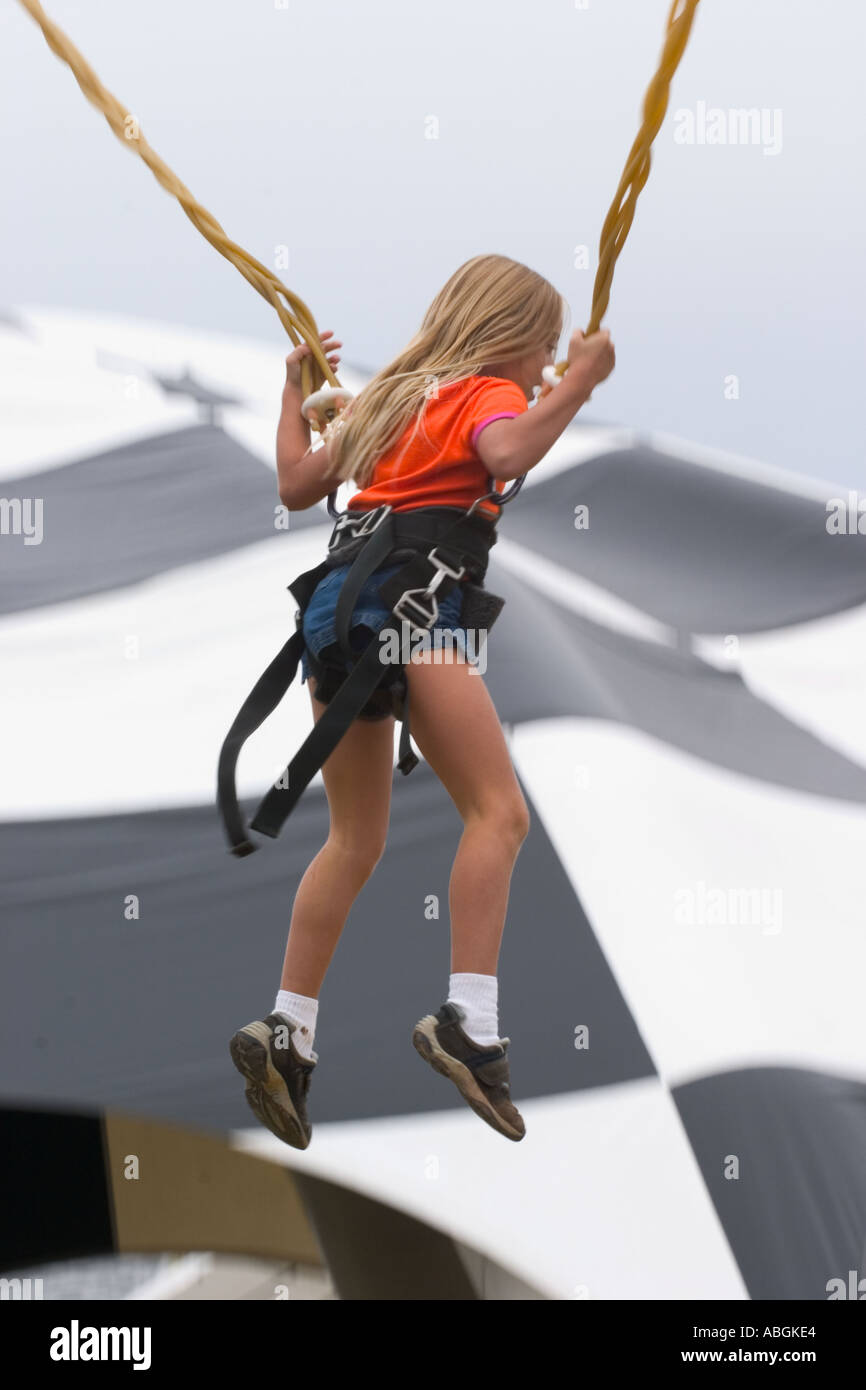 Young girl on a bungee cord type ride at a Connecticut USA fair Stock
