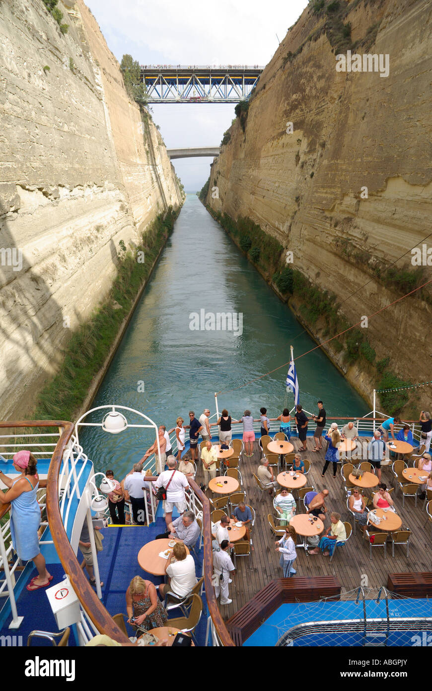 Tight squeeze for cruise ship passing through historical Corinth Canal passengers at tables & chairs on stern leisure deck Peloponnese Greece Europe Stock Photo