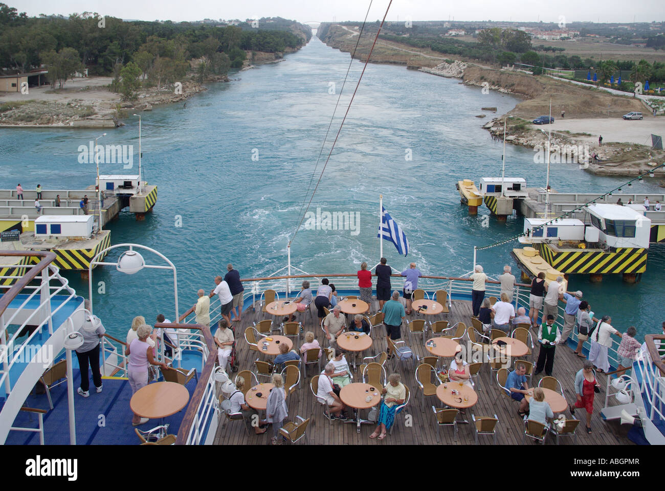 Passengers on stern leisure deck of Cruise ship passing over submersible road bridge across Corinth Canal connects Gulf of Corinth with Saronic Gulf Stock Photo