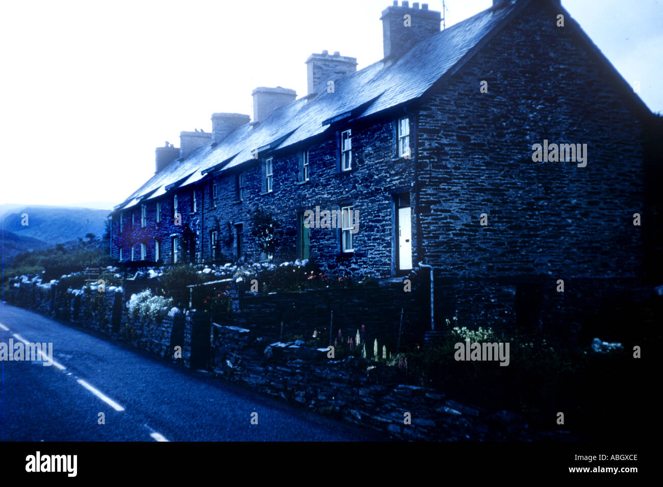 Stone Cottages With Snowdonia Behind Rainy Day In North Wales