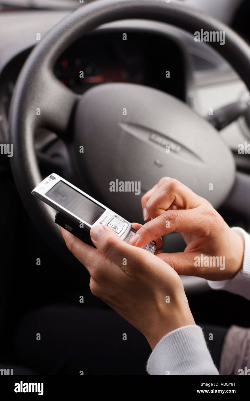 Women driver texting on a mobile phone while driving Stock Photo
