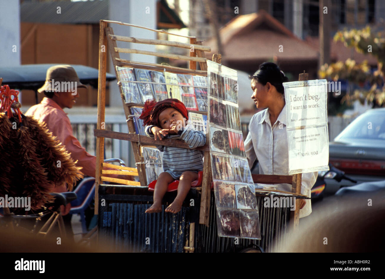 Postcard Seller/Street hawker with young child advocating 'selling, not begging,' Siem Reap, Cambodia Stock Photo