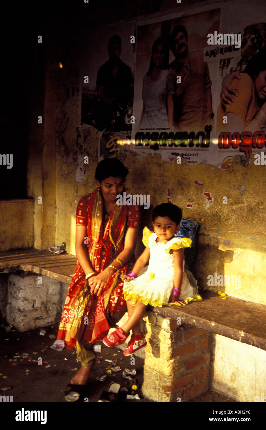 Indian mother and child in bus shelter waiting for bus, Kerala, South India Stock Photo
