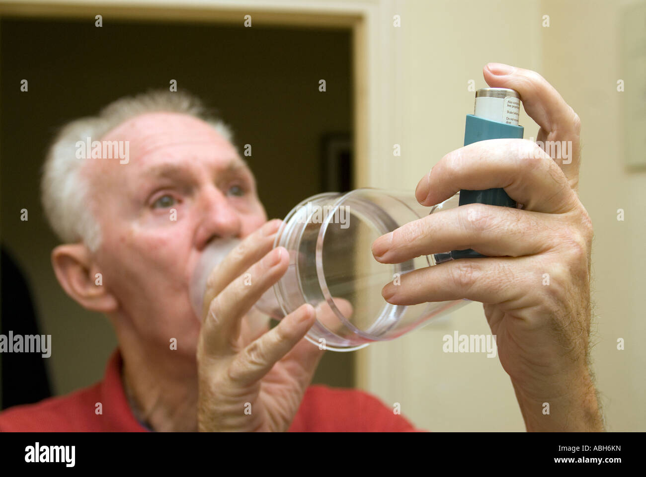 71 year old elderly man with asthma using a paediatric volumatic spacer and ventolin to alleviate symptoms, Hounslow, west London, UK. Stock Photo