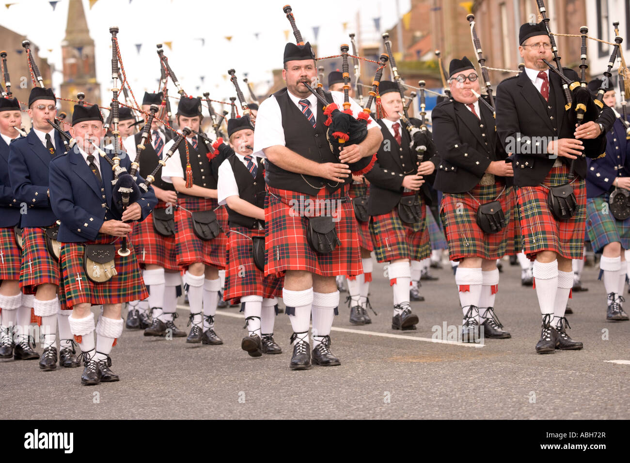 Scottish traditional music bag pipers pipe band marching down Annan High Street Scotland UK Stock Photo