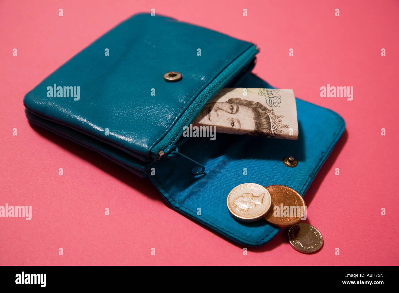 Blue leather purse and five pound bank note and coins. Stock Photo
