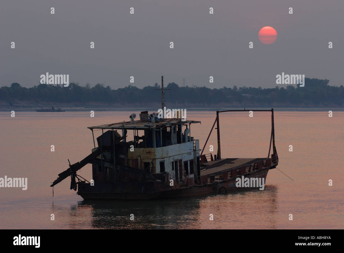 A rusting vessel lies at anchor in the flow of the Mekong river near Pakse in southern Laos. Stock Photo