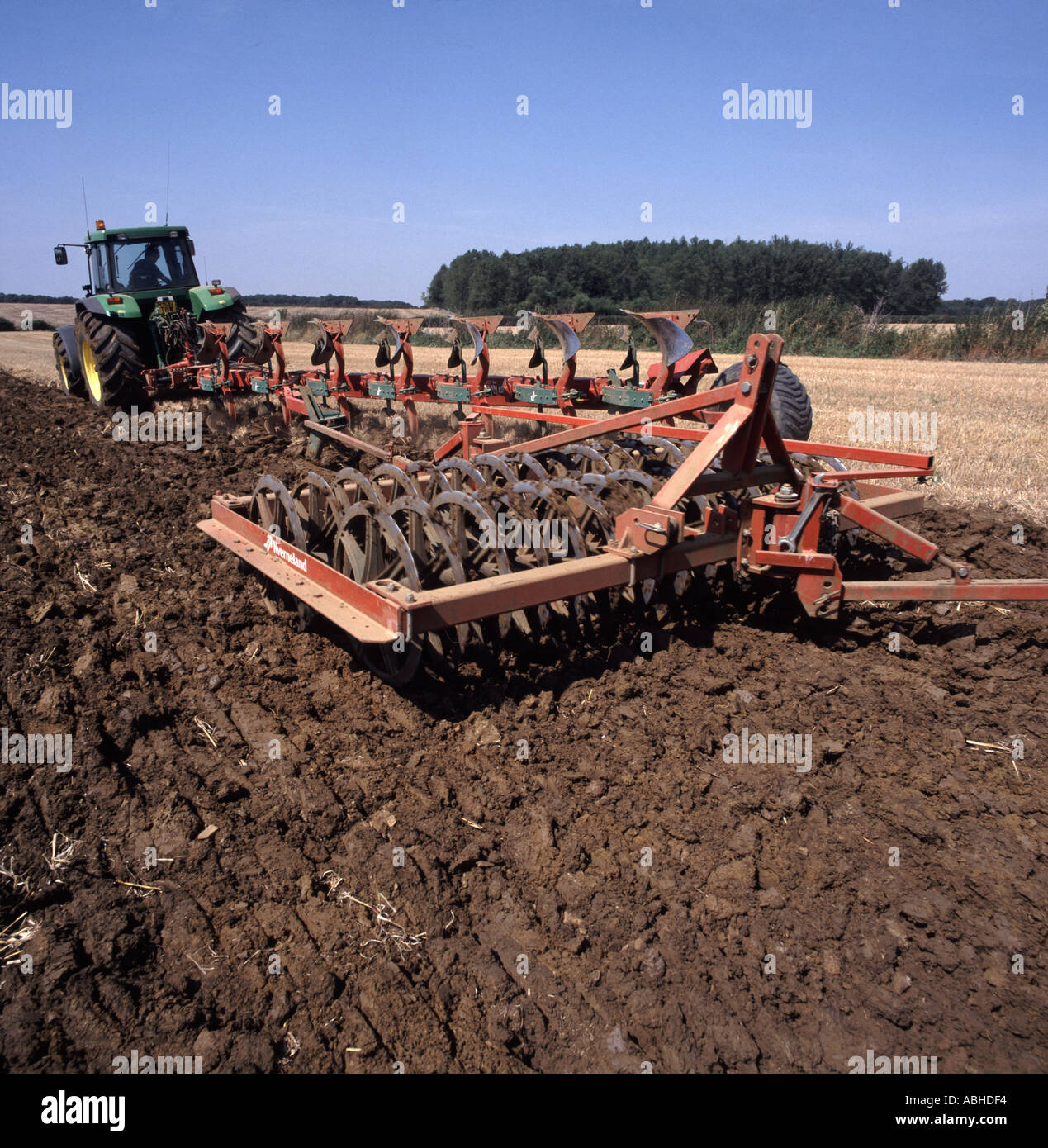 John Deere seven coulter plough and press cultivating stubble field in the Cotswolds UK Stock Photo