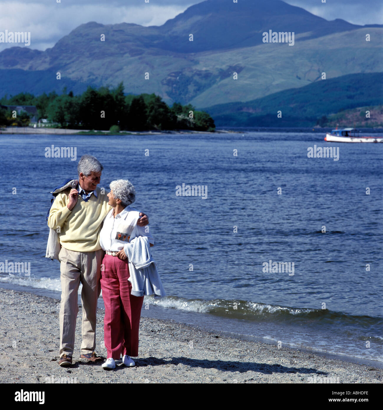 COUPLE WALKING ON BEACH LOCH LOMOND.MODEL RELEASE AVAILABLE ON REQUEST . Stock Photo
