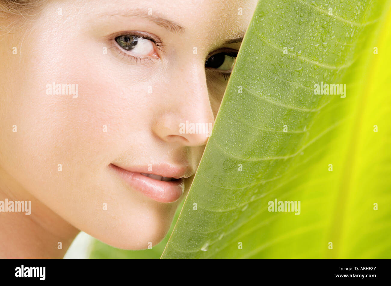 Portrait of a young woman looking at the camera, banana leaf, outdoors ...