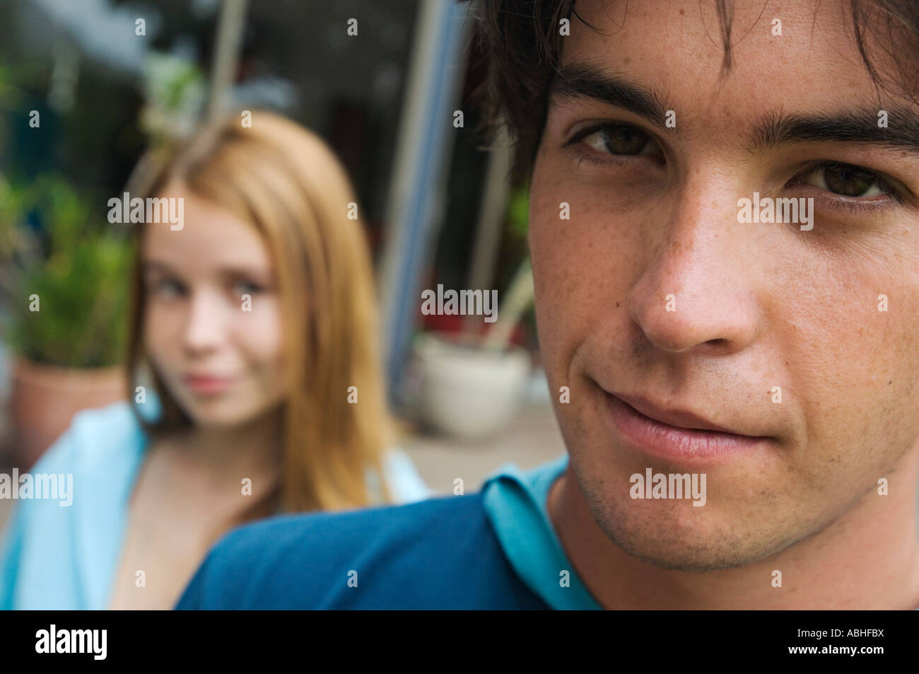 Portrait of a teenage boy looking at the camera, teenage girl in ...