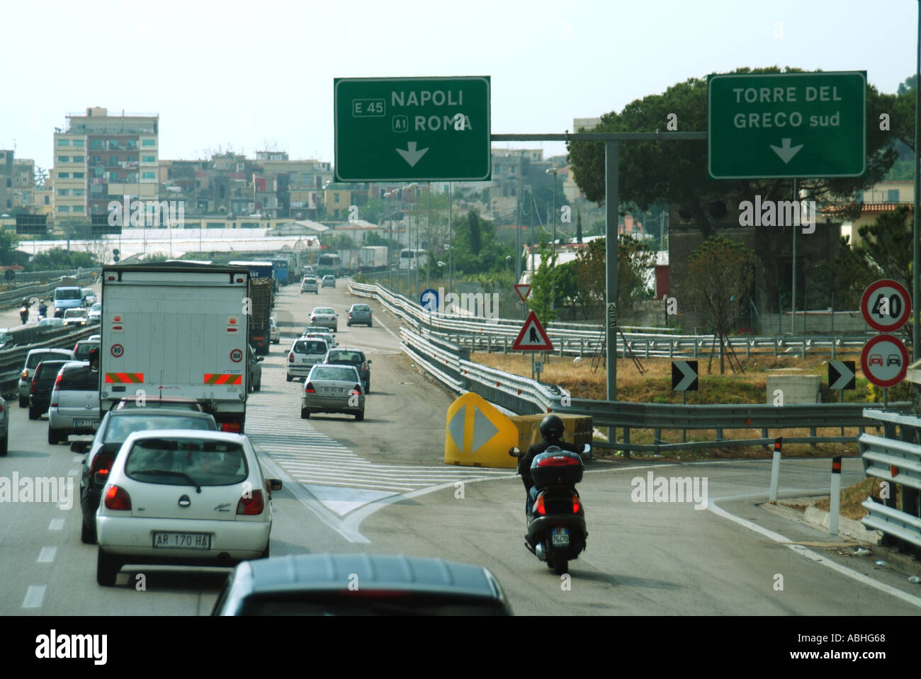 Motorists stuck in grid lock traffic jam on Italian toll road heading towards Naples with empty slip road at junction Stock Photo