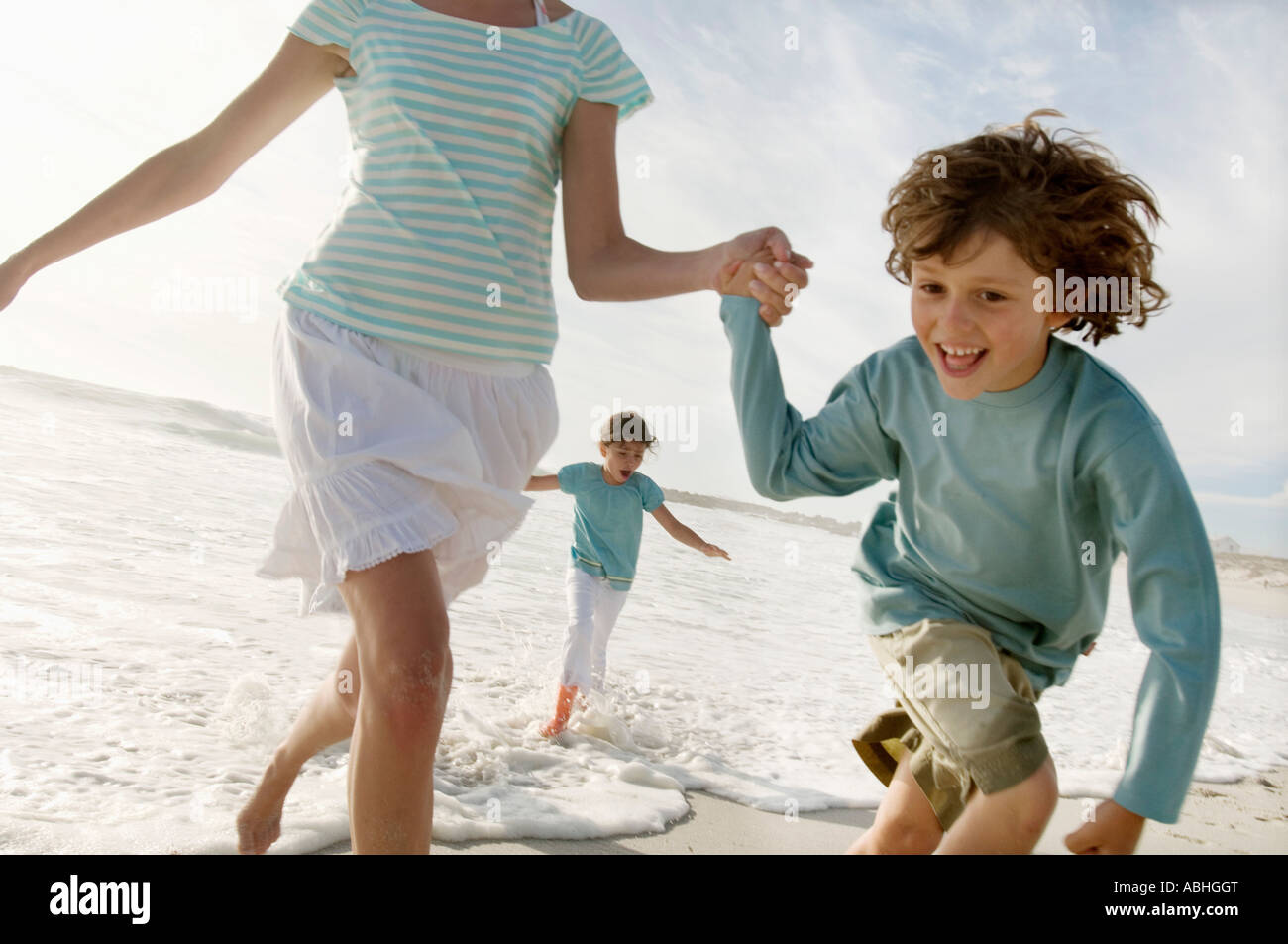 Family running on the beach Stock Photo