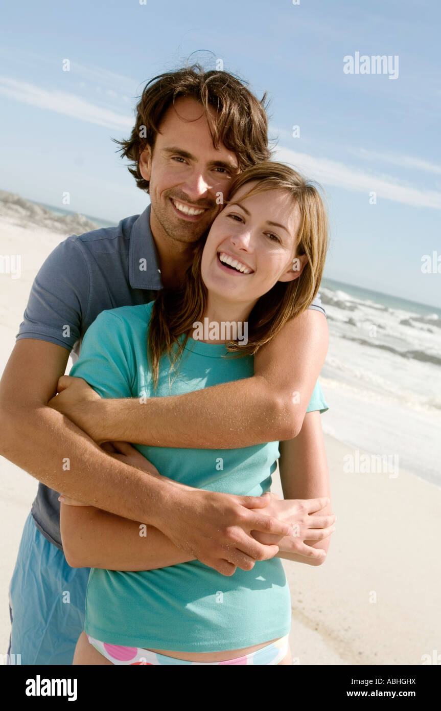 Couple in an embrace, on the beach, posing for the camera, outdoors Stock Photo