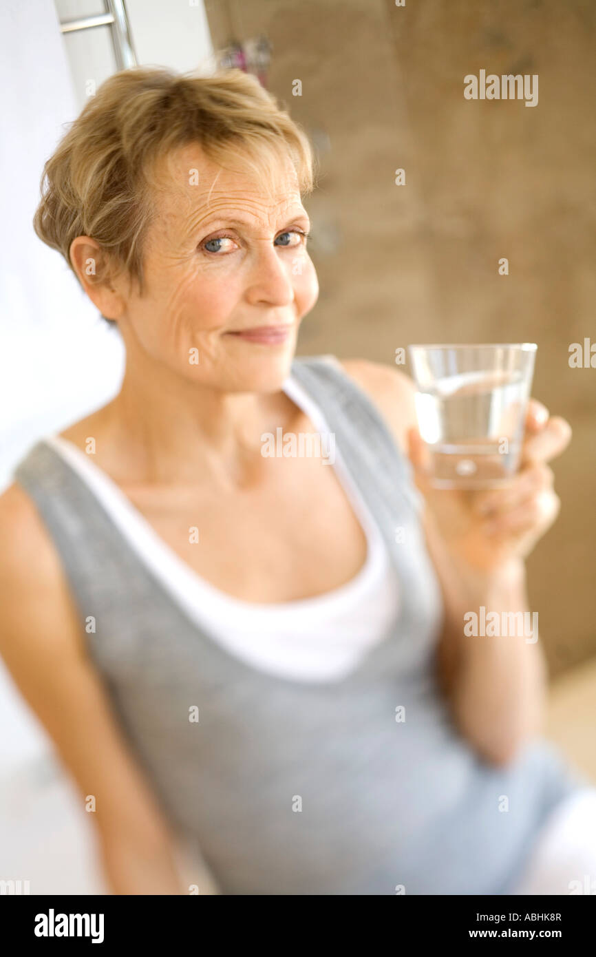 Senior woman holding glass of water Stock Photo - Alamy