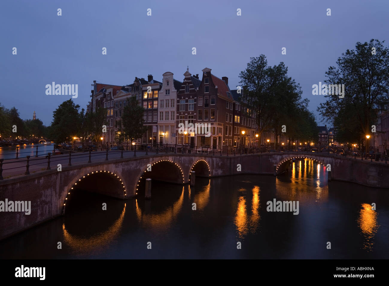 View over illuminated bridge to gabled houses in the evening Keizersgracht and Leidsegracht Amsterdam Holland Netherlands Stock Photo