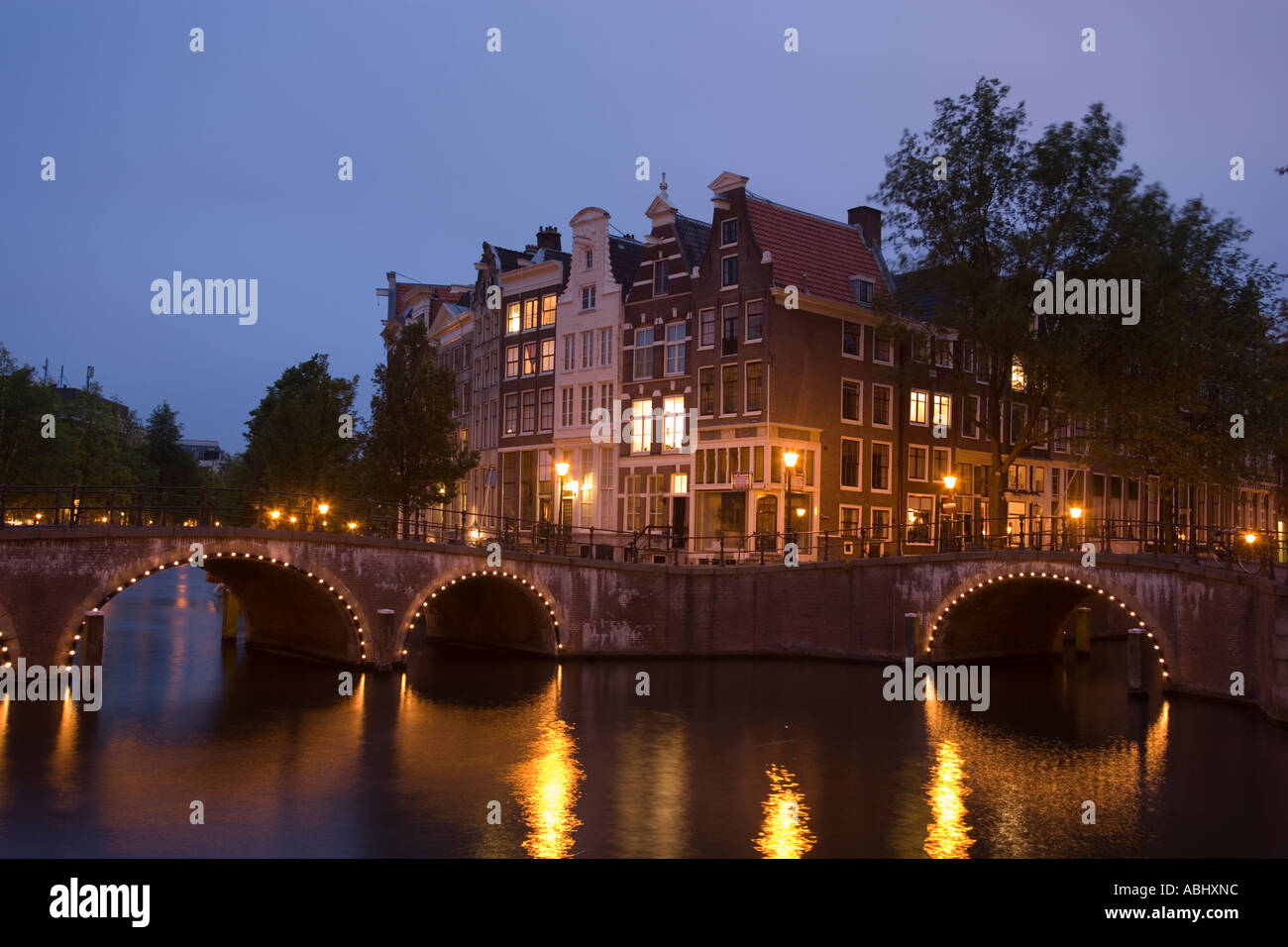 View over illuminated bridge to gabled houses in the evening Keizersgracht and Leidsegracht Amsterdam Holland Netherlands Stock Photo