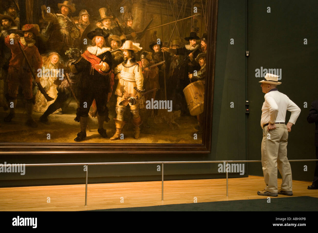 Man looking at The Nightwatch a painting by Rembrandt van Rijn Rijksmuseum Amsterdam Holland Netherlands Stock Photo