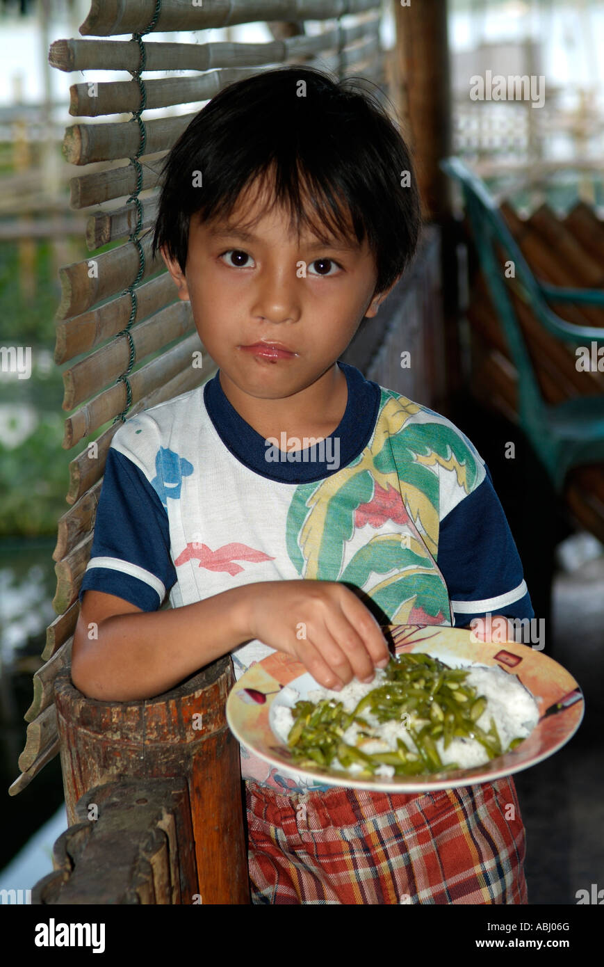 Young indonesian boy eating rice in his house , North Sulawesi Stock Photo