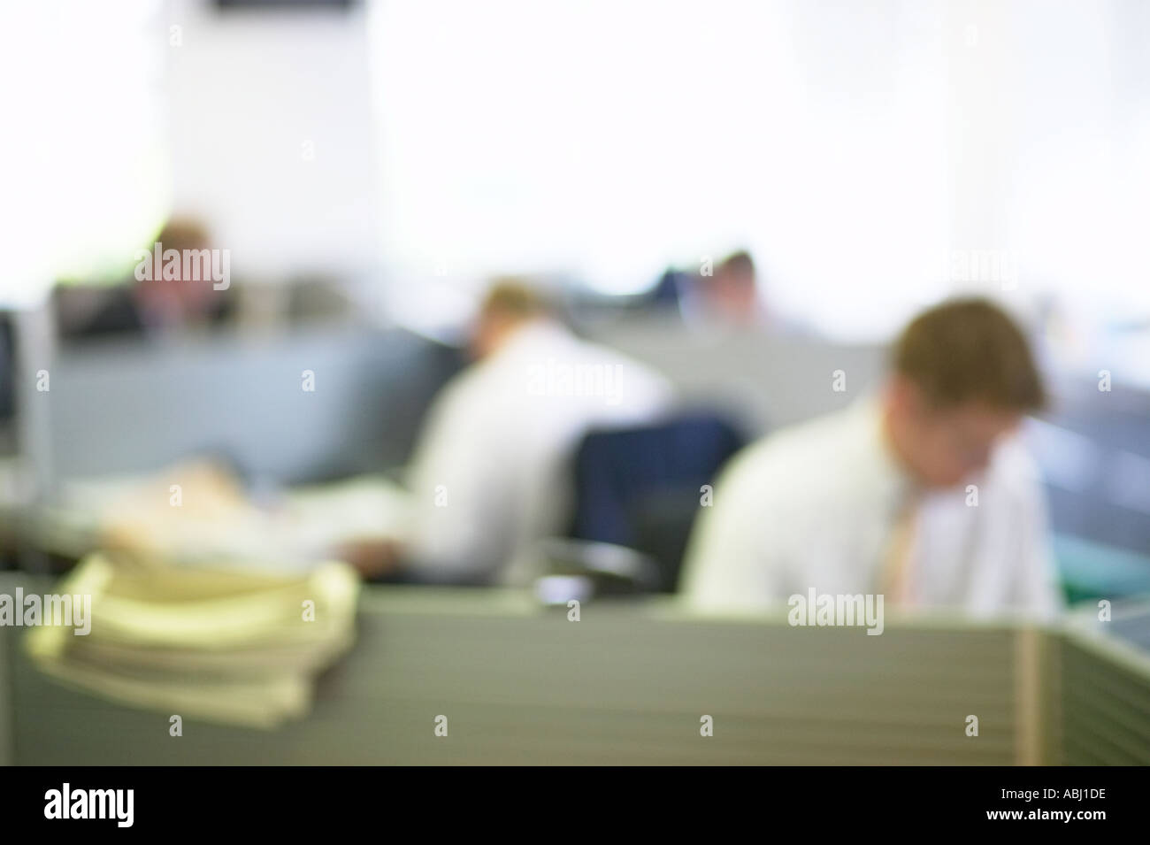 out of focus blurred view of men working in open plan office Stock Photo