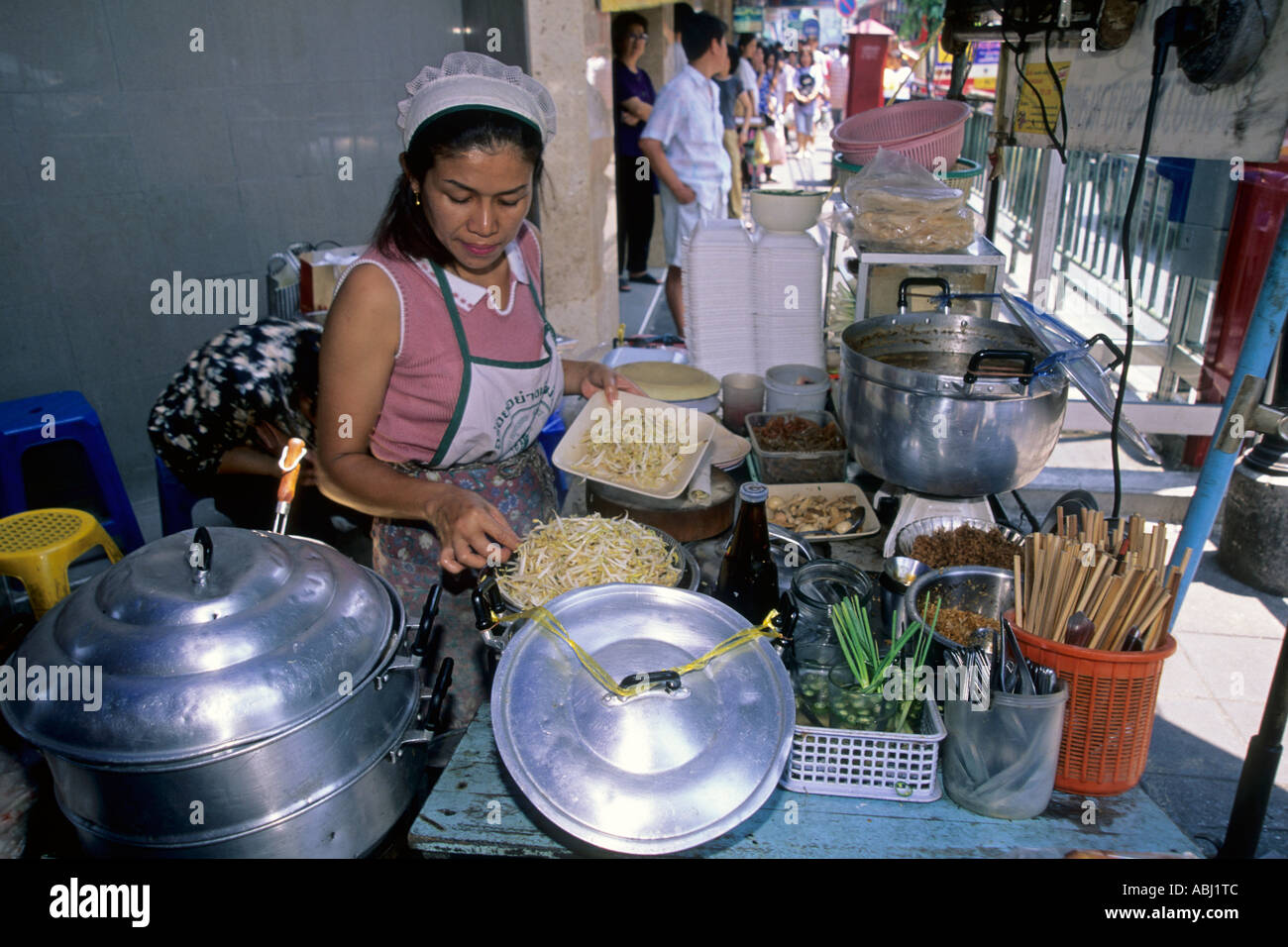 Woman preparing food on stall in street market, Pattaya, Tahiland Stock Photo