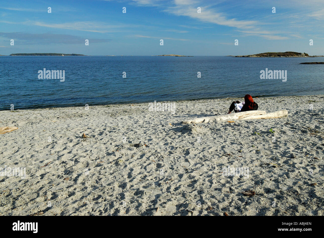 Woman resting on a sandy beach in Victoria Stock Photo