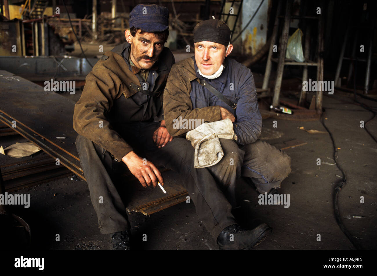 Gdansk, Poland. Two tired shipyard workers taking a cigarette break. Stock Photo