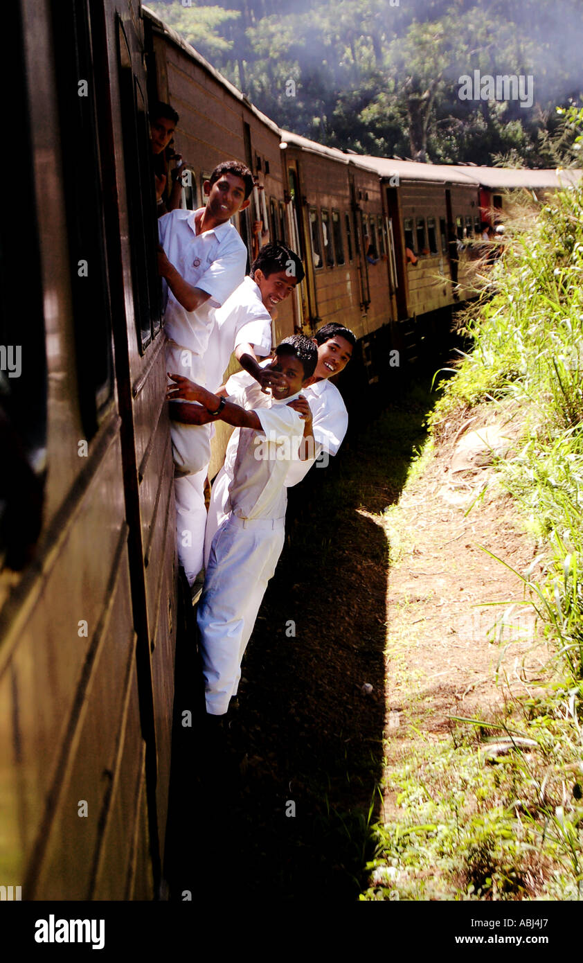 School Children leaning out of a moving train - Sri Lanka Stock Photo