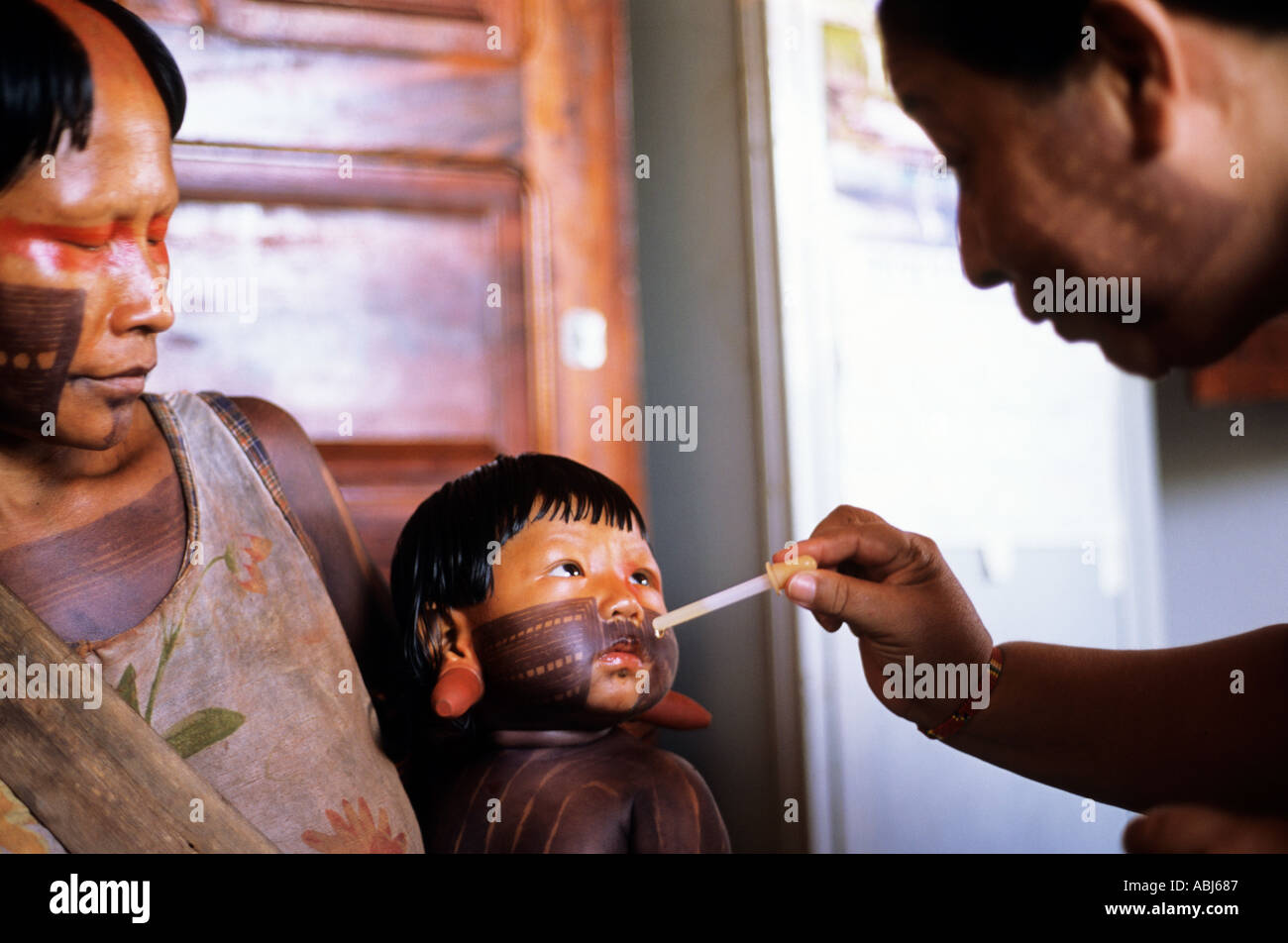 Bacaja village, Amazon, Brazil. Nurse Wanda administers vaccine in drops to baby with his mother in the health post; Xicrin tribe. Stock Photo