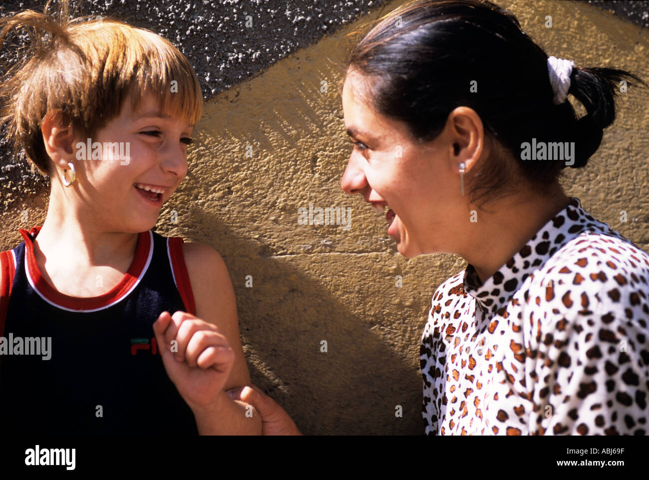 Romania. Two schoolgirls in the playground smiling at each other. One ...