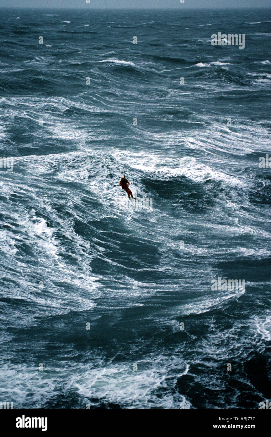 Rough sea and waves with helicopter rescue man on winch Stock Photo
