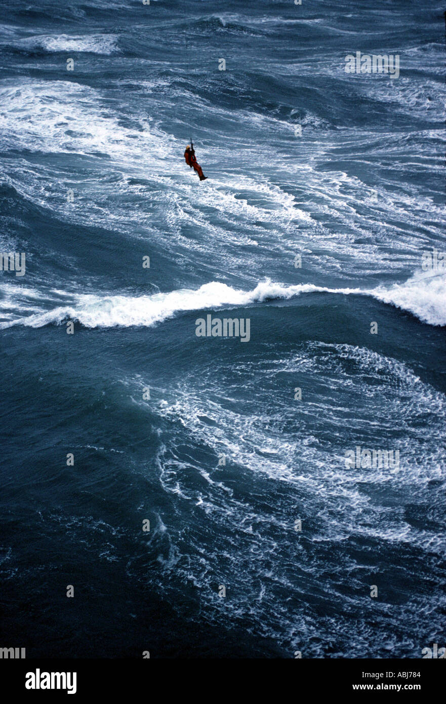 Helicopter winch man above rough sea and waves Stock Photo